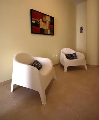 two white chairs are sitting in a room at Apartamentos Plaza - Albufeira in Albufeira