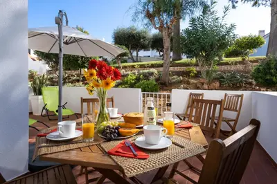 a wooden table with a vase of flowers on it at Apartamento Yacintos in Albufeira