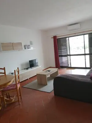 a living room with a bed and a table at apartamento em albufeira in Albufeira