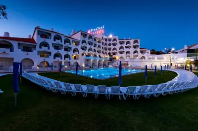 a view of the hotel and the pool at night at Tropical Sol in Albufeira