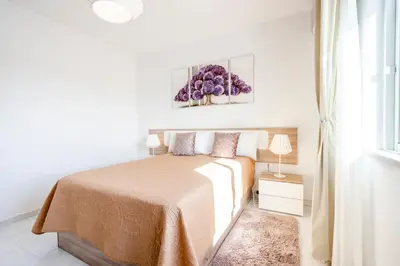 a white bedroom with a bed and a window at My Place @ Faro Ria Views in Faro