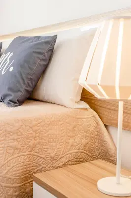 a bed with a pillow on it next to a table at My Place @ Faro Ria Views in Faro