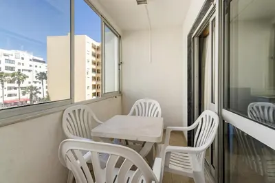 a small table and chairs in a room with a window at Paula Bela by Garvetur in Quarteira