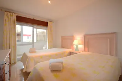 a bedroom with two beds and a window at Paula Bela by Garvetur in Quarteira