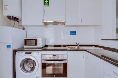 a kitchen with a washing machine and a microwave at AL - Apartamento Vista Marina 1 in Vilamoura