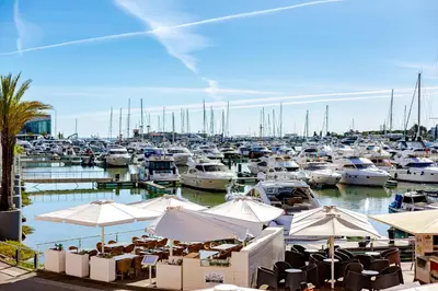 a marina with many boats and tables and umbrellas at AL - Apartamento Vista Marina 1 in Vilamoura