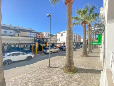a street with parked cars and palm trees on a city street at AL - Apartamento Vista Marina 2 in Vilamoura