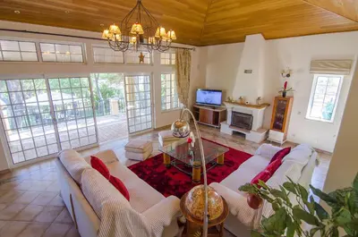 a living room with white furniture and a chandelier at Villa Lira in Almancil