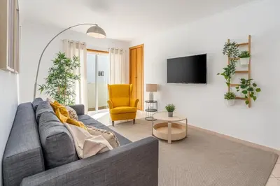 a living room with a gray couch and a yellow chair at #001 Veríssimo Flat by Home Holidays in Albufeira