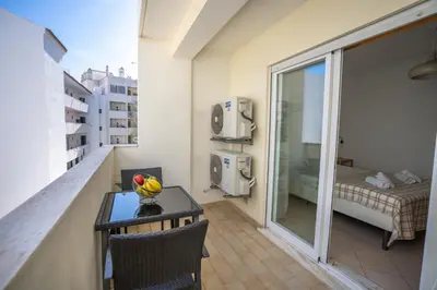 a balcony with a table and a room with a bed at #001 Veríssimo Flat by Home Holidays in Albufeira