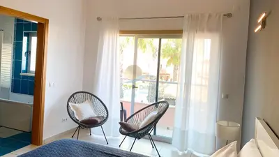 a bedroom with two chairs and a bed and a window at Villa Jardins 2 by Sunny Deluxe in Albufeira