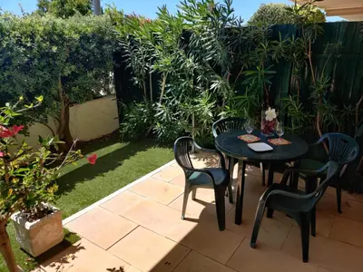 a patio with a table and chairs in a garden at Albufeira Monte Balaia in Albufeira