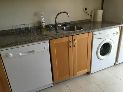 a kitchen with a sink and a washing machine at Albufeira Monte Balaia in Albufeira