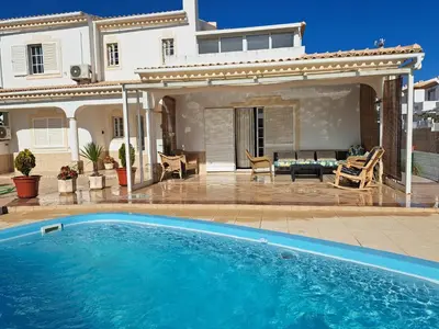 a swimming pool in front of a house at Villa Casanova in Albufeira