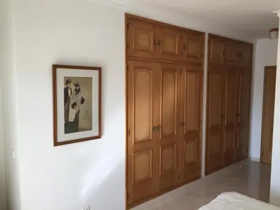 a bedroom with wooden cabinets and a picture on the wall at Moradia Galé in Guia