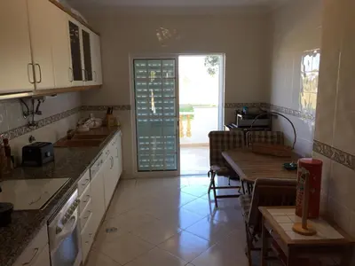 a kitchen with a table and a dining room at Moradia Galé in Guia