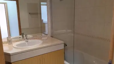 a bathroom with a sink and a shower at Vista das Ondas Olhos de Agua in Albufeira