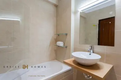 a bathroom with a sink and a mirror and a tub at T1 Grevilias em Vilamoura - Greice Homes in Quarteira