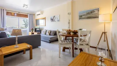 a living room with a couch and a table at T1 Grevilias em Vilamoura - Greice Homes in Quarteira