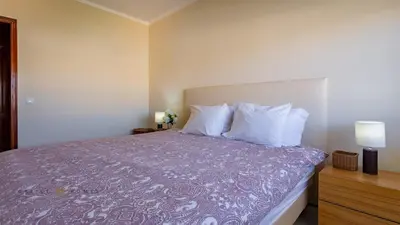 a bedroom with a bed with purple sheets and white pillows at T1 Grevilias em Vilamoura - Greice Homes in Quarteira