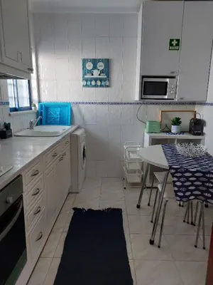 a kitchen with a sink and a table in it at Quarteira T1 - Oceanides in Quarteira