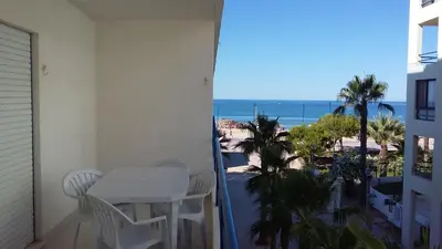 a balcony with a table and chairs and a view of the beach at Quarteira T1 - Oceanides in Quarteira