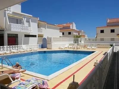 a swimming pool in front of a villa at Apartamento Oura T1 Beach 200m in Albufeira