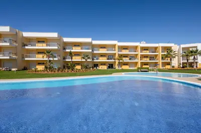a large swimming pool in front of a building at Marina Luxury Residence - Albufeira in Albufeira