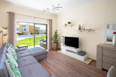 a living room with a couch and a flat screen tv at Marina Luxury Residence - Albufeira in Albufeira