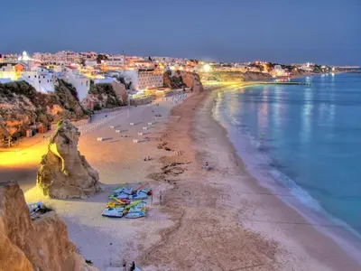a view of a beach at night with people on it at Luxury 3 Bedroom Apartment, Albufeira Resort in Albufeira