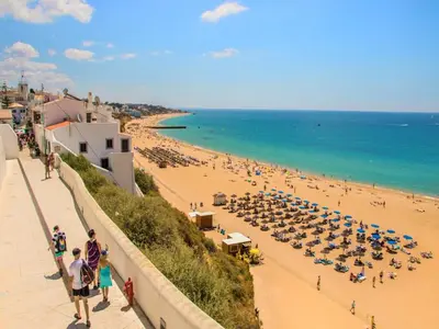 a beach with a crowd of people and umbrellas at Luxury 3 Bedroom Apartment, Albufeira Resort in Albufeira