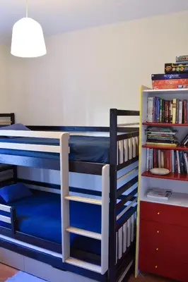 a bedroom with two bunk beds and a book shelf at Faro Beach House in Faro