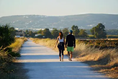 a man and woman walking down a road at Faro Beach House in Faro