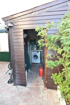 a shed with a washing machine in it at Faro Beach House in Faro
