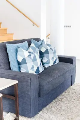 a blue couch with blue and white pillows on it at Casas Barulho Penthouse Old Town in Albufeira