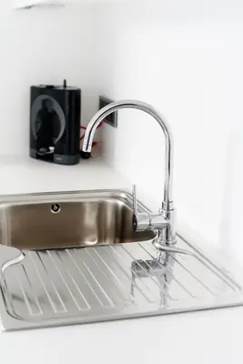 a stainless steel sink in a kitchen with a black appliance at Casas Barulho Penthouse Old Town in Albufeira