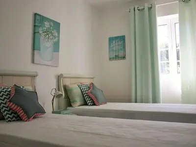a bedroom with two beds and a window at T3 Townhouse Old Village Vilamoura in Vilamoura