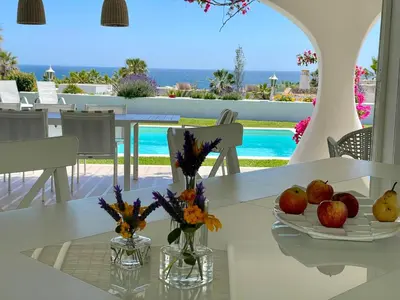 a table with fruits and flowers on it on a patio at Vila Marine in Albufeira