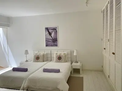 a white bedroom with a large bed with two pillows at Vila Marine in Albufeira