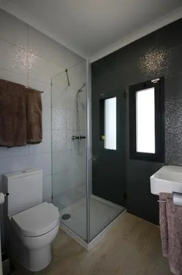 a bathroom with a shower and a toilet and a sink at L&F House in Algoz