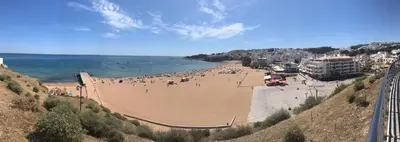 a beach with a bunch of people on it at Belavista Apartment in Albufeira