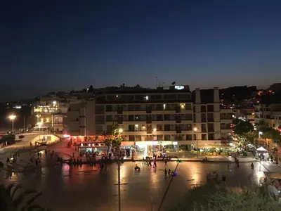 a city at night with people walking around in the street at Belavista Apartment in Albufeira