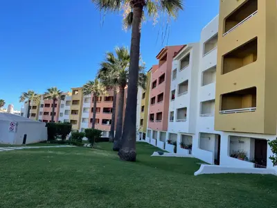 a row of apartment buildings with palm trees at Belavista Apartment in Albufeira
