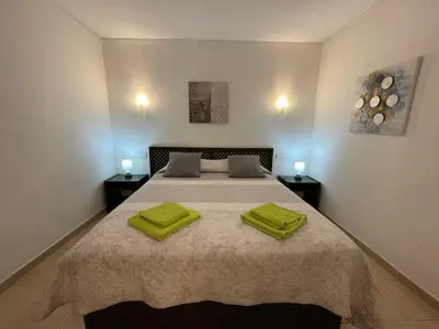 a bedroom with a bed with two yellow towels on it at Belavista Apartment in Albufeira