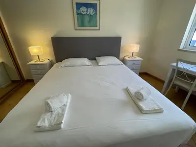 a large white bed with two towels on it at Palm Garden in Vilamoura