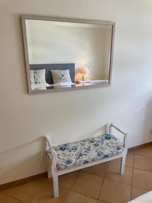 a mirror on a wall with a bench under it at Palm Garden in Vilamoura