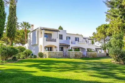 a large white house with a large yard at Four Seasons Country Club in Quinta do Lago