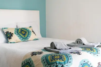 a bed with towels and pillows on top of it at Apartamento Mar in Quarteira