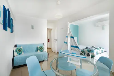a living room with a glass table with a sailboat on it at Apartamento Mar in Quarteira
