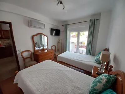 a hotel room with two beds and a mirror at Regueiró Quarteira Beach Apartment in Quarteira